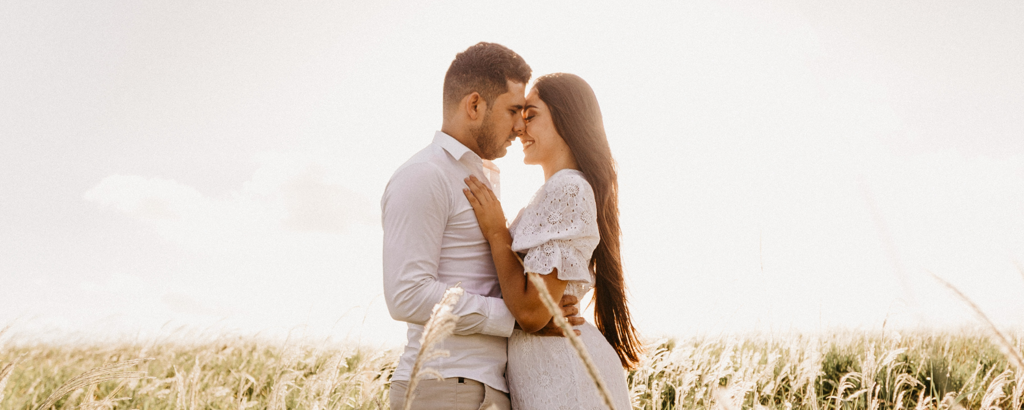 couple embracing for a photoshoot in an open meadow 